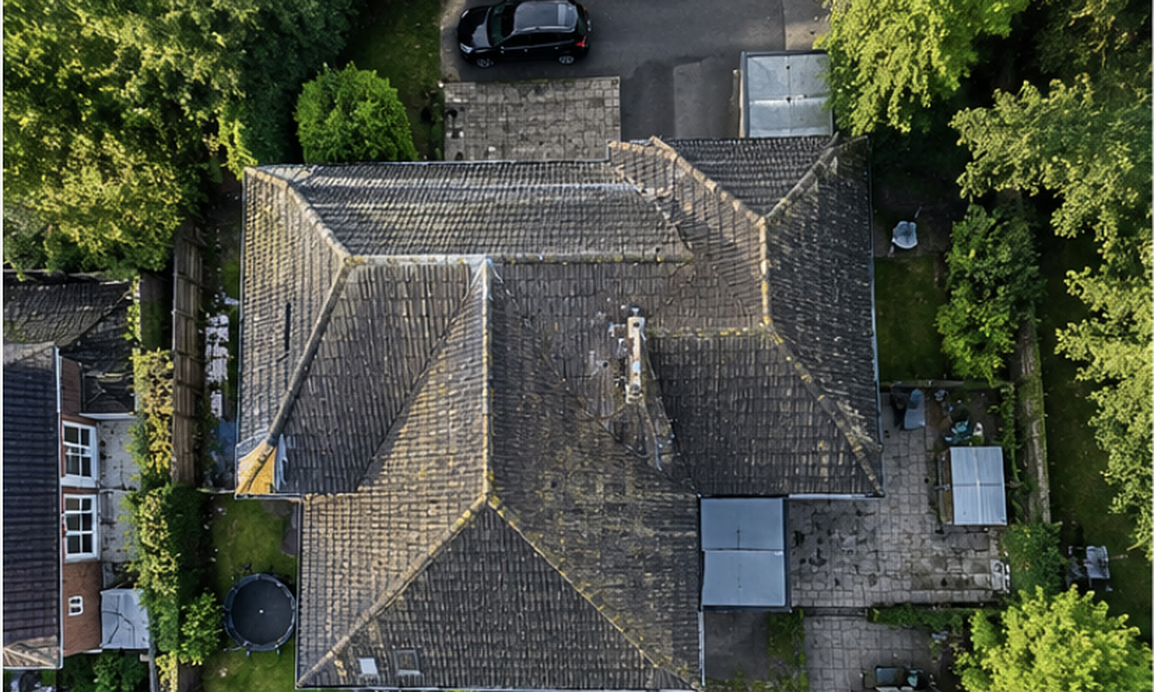 Top-down drone photo of a hipped tile roof on a Bristol house, with the chimney, flat roof section and hips marked in red